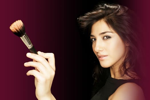 Neda mit einem Make-up-Pinsel in der erhobenen Hand
